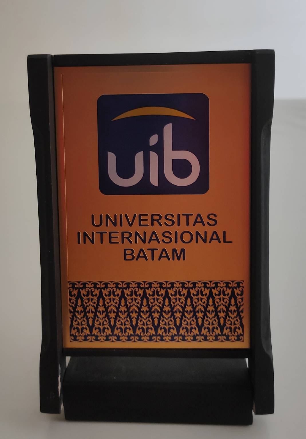 2016年11月7日印尼巴淡國際大學(Universitas Internasional Batam, UIB)致贈木製鍍金校徵立牌的圖檔，第1張，共2張