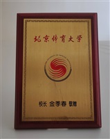 1998年12月1日北京體育大學（Beijing Sport University）致贈木製鍍金校徽立牌的圖片