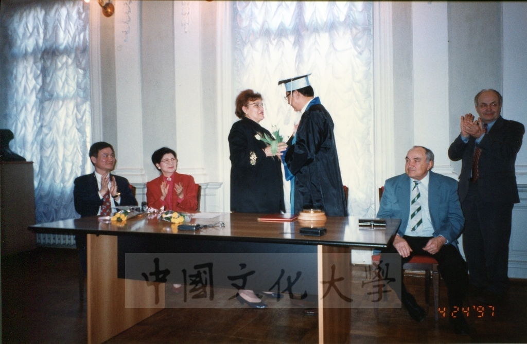 1997年4月23日及24日董事長張鏡湖帶領校長林彩梅、學務長高輝、俄研所所長明驥及國際學術合作組組長孫德宜拜會俄羅斯聖彼得堡大學，張董事長並榮獲該校名譽博士學位，由該校校長薇爾碧芝卡雅女士親自頒贈的圖檔，第17張，共32張