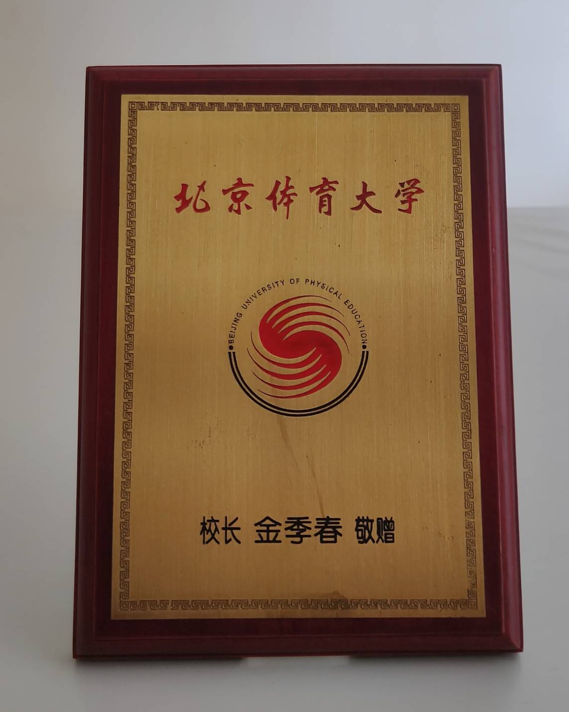 1998年12月1日北京體育大學（Beijing Sport University）致贈木製鍍金校徽立牌的圖檔，第1張，共1張