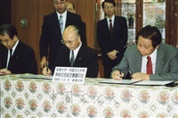 1995年7月8日董事長張鏡湖率同校長林彩梅等五人參訪創價大學，並舉辦雙方簽訂姐妹校儀式，由張董事長、林校長及創大總長高松和男、校長小室金之助代表簽訂合約書的圖片