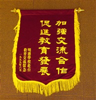 1999年6月明德學校致贈「加強交流合作　促進教育發展」錦旗的圖片